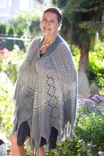 Plus size woman smiling in a cozy knit poncho fall layering outfit
