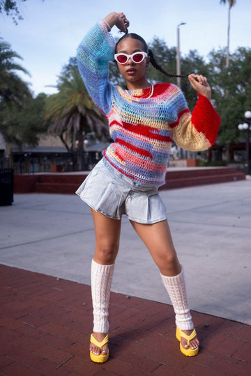 1980s flared leg warmers styled with a neon striped sweater on a retro running track