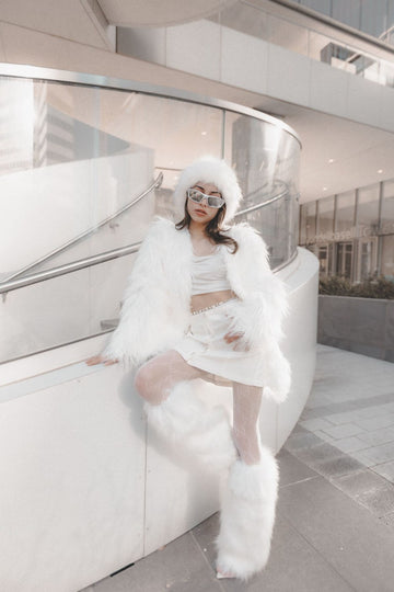 Fluffy leg warmers outfit with white faux fur pieces styled for a city winter walk