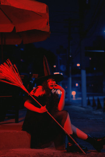 Plus size woman in witch costume posing outdoors for Halloween celebration