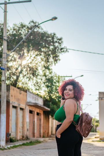 Smiling plus size woman posing on city street in casual back to school outfit