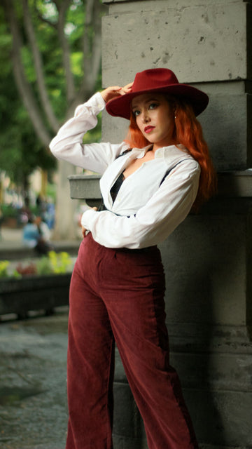Woman in a chic outfit featuring corduroy pants and a red hat