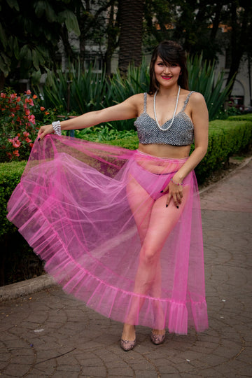 Woman wearing a vibrant pink tulle skirt posing outdoors in a fashion street style outfit