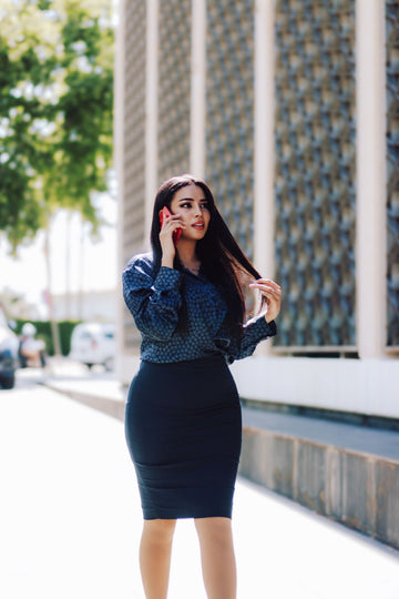 Woman in pencil skirt and blouse workwear outfit walking on city street office fashion