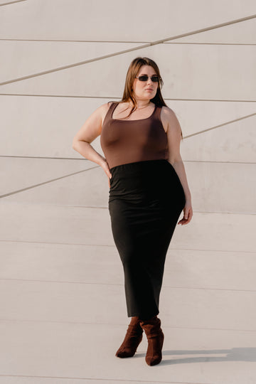 Confident plus size woman wearing a stylish midi skirt outfit outdoors in an urban setting