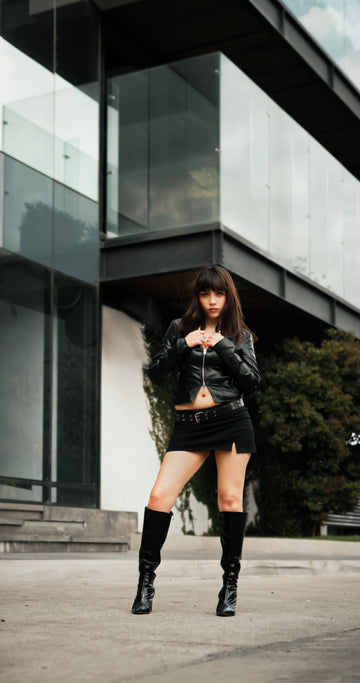 Confident plus size woman wearing mini skirt posing outside modern building in summer street style