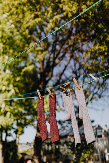 Clean cotton compression socks drying on an outdoor clothesline in daylight