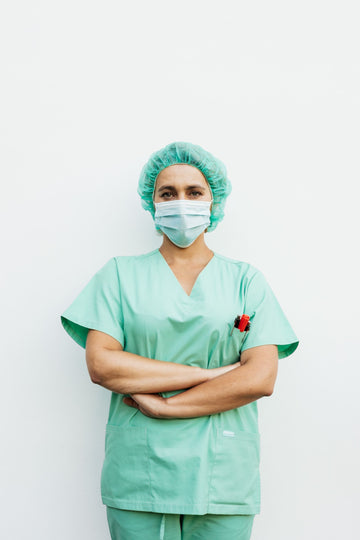 Nurse in scrubs standing with arms crossed during a long shift wearing supportive compression socks for nurses