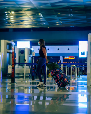 Woman walking through an airport with luggage in a comfortable plus size travel outfit