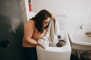 Plus size clothing care with a woman unloading washed clothes from a washing machine