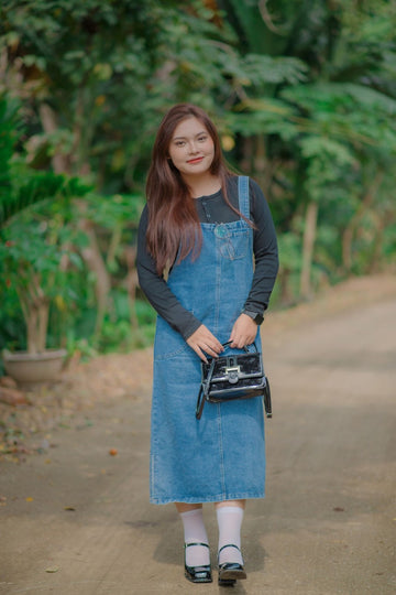 Plus size denim overall dress with bib straps styled for a casual outdoor walk