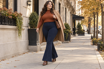 Plus size woman wearing navy flared pants with a rust sweater for fall