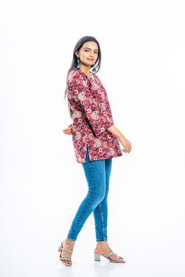 Woman wearing a floral tunic over jeans, a versatile plus size layering staple