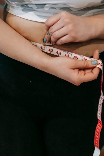Plus size overall dress fit guide measuring the waist with a sewing tape