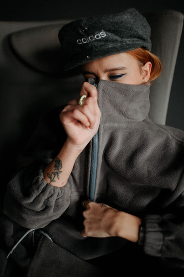 Woman wearing a gray plus size quarter zip fleece pullover with a high zip collar