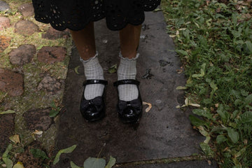 Plus size ruffle socks with black mary jane shoes on a leaf strewn garden path