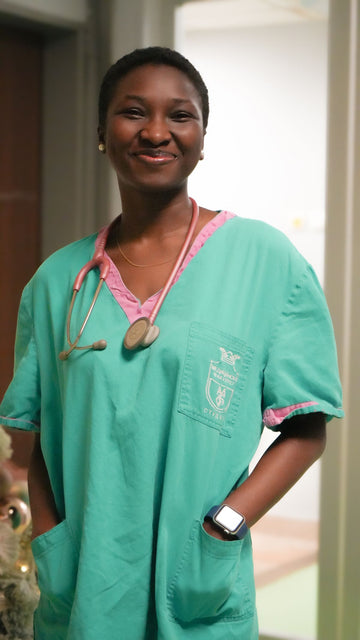 Plus size scrubs worn by a smiling nurse in a hospital corridor