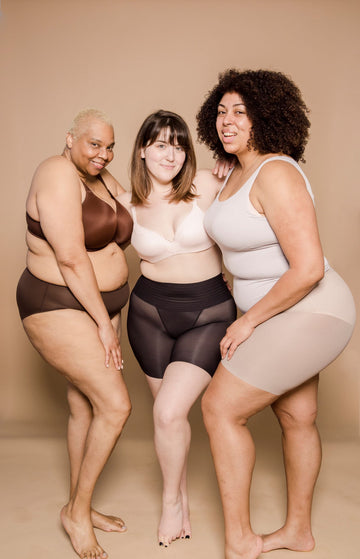 Plus size women standing together in shaping underwear, showing body-positive fit