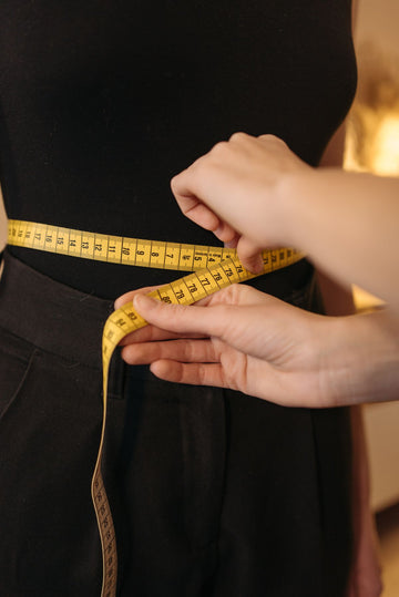 Plus size size guide with a measuring tape measured around the waist for a perfect fit