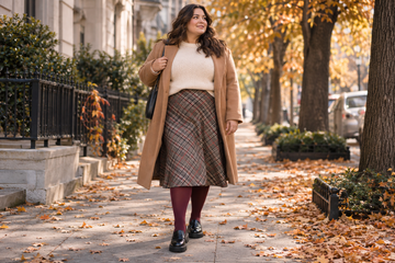 Plus size woman wearing burgundy tights with loafers and a plaid midi skirt in fall