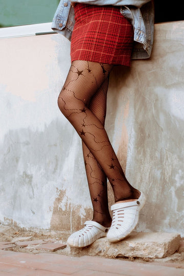 Silicone stay up stockings in sheer black worn with a plaid mini skirt and sneakers